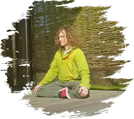 Jean Meditating on a wooden platform on a sunny day.